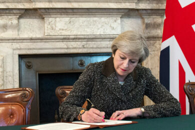 Theresa May ondertekent de brexit-papieren. - Foto: ANP
